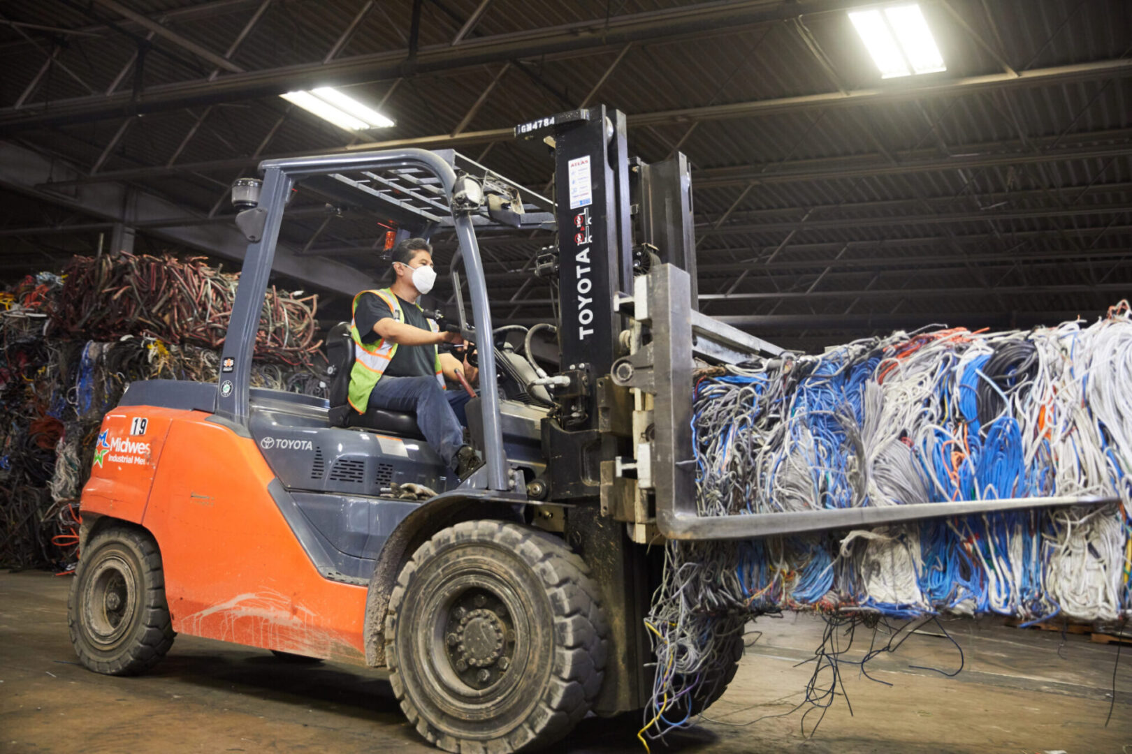 A man in an orange and white forklift.