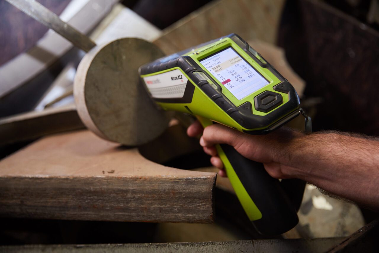 A person using a handheld device to check the wood.